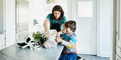 a woman folding clothes with her son
