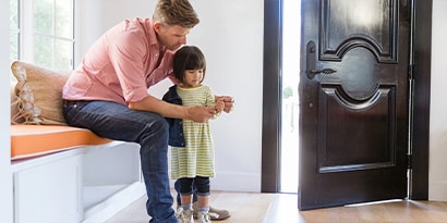 Man putting jacket on child