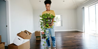 Woman holding plant in empty room