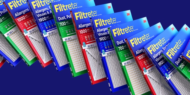 A wave of overlapping Filtrete filters on a dark blue background.
