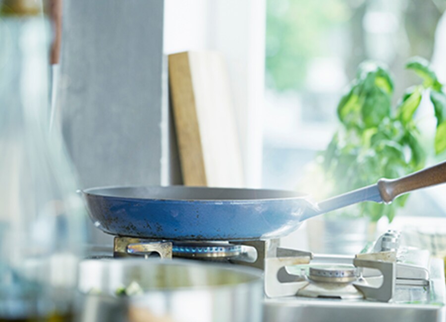 Blue Frying Pan on Lit Stove
