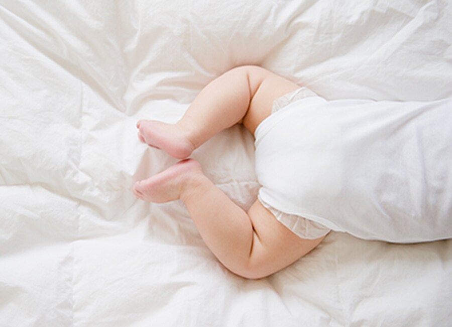 Baby legs on White Comforter
