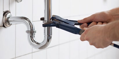 Hands fixing a pipe