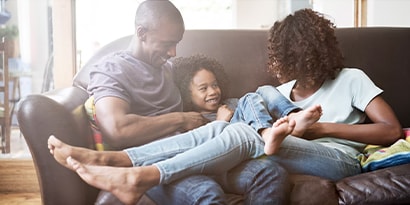 a family sitting on a couch together smiling.