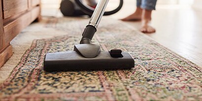 Consult our top tips for affordable ways to improve your indoor air. Close up of a vacuum being used on a rug.
