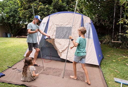 A family setting up a tent a the backyard.