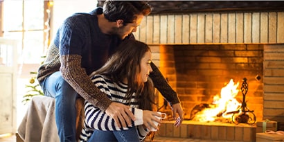 Couple sitting next to a fireplace