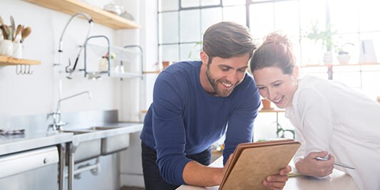 a couple looking at an iPad together.
