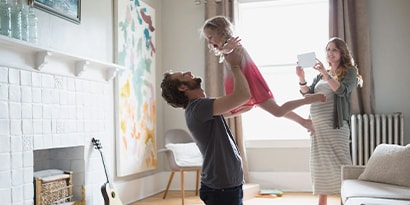 Father playing with child in a living room.