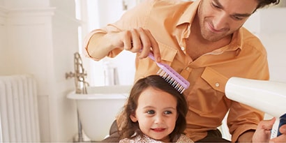 A father doing his daughters hair