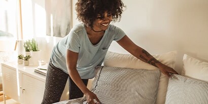 A woman making her bed.
