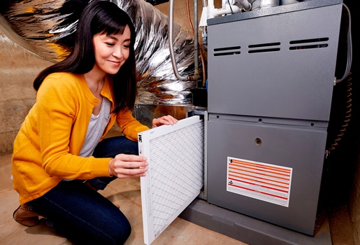 Familiarizing yourself with some HVAC basics can help maximize the comfort in your home. Lady changing Filtrete filter.