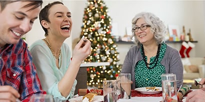 A woman laughing with holiday guests
