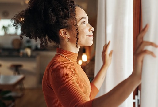 A person opening a window. Woman looking outside an open window.