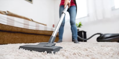 a close up of a vacuum, vacuuming a carpet.
