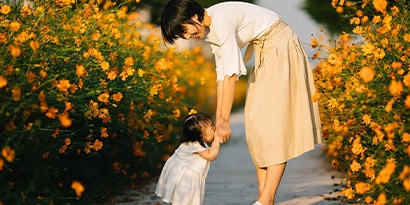 Woman with child in a field of flowers.