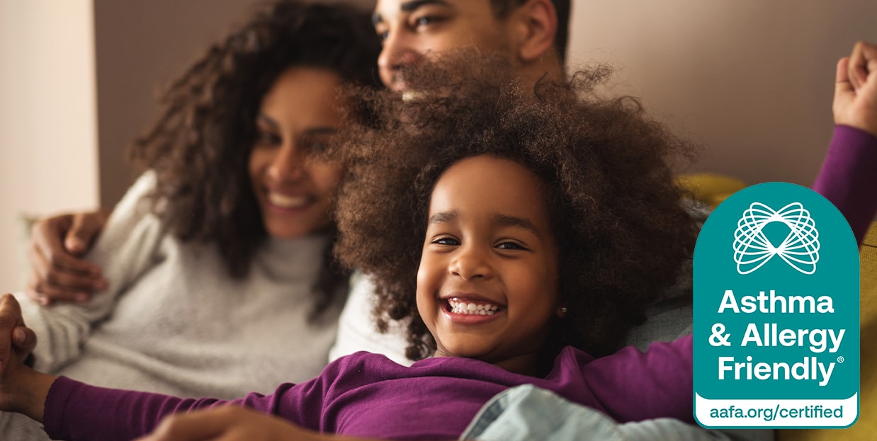 Smiling child with parents, next to a 