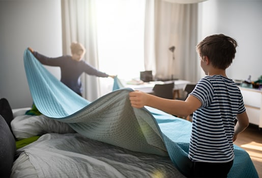 Five bugs you might find in your home, plus tips to get rid of them. Two people making a bed together.