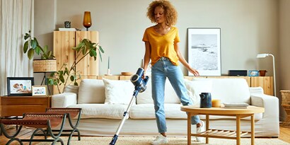 Use your five senses to help determine what to clean next. A woman vacuuming a living room.
