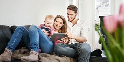 a family looking at a tablet on the couch
