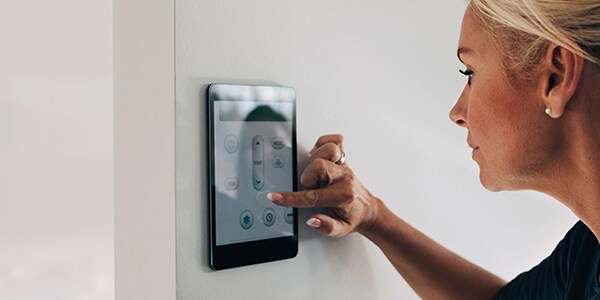 Woman using a smart thermostat
