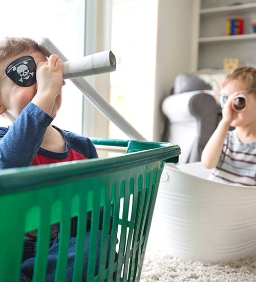 Kids playing in laundry baskets in house