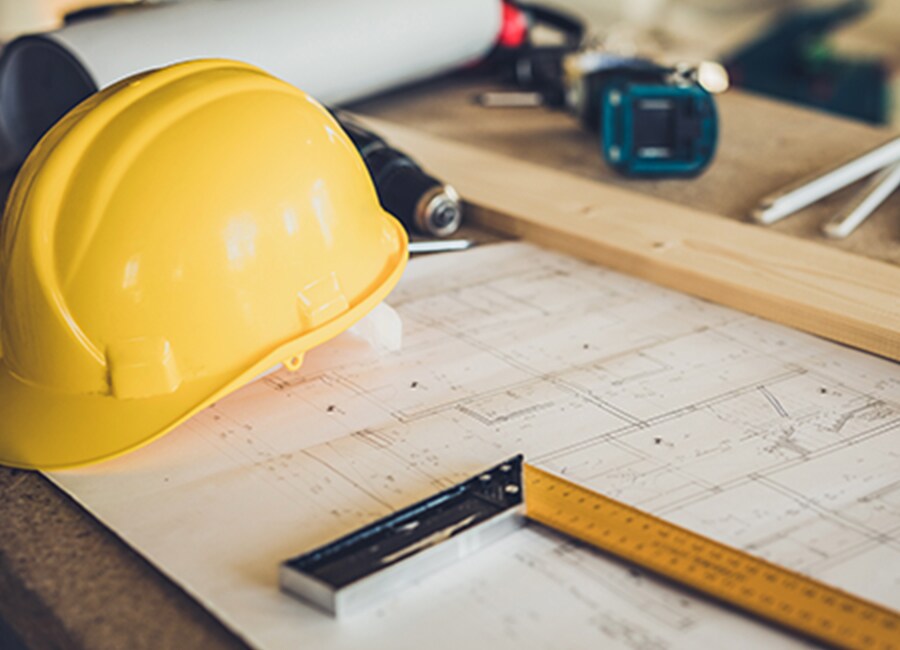 Hard Hat and Blue Prints at Construction Site
