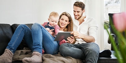 A family looking at a tablet together on the couch