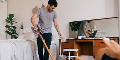 Man vacuuming his office.

