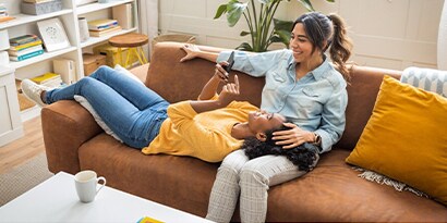 These seven apps will help you stay more organized in the new year. Two women sitting on a couch, one is on her phone
