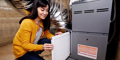 Woman replacing HVAC filter