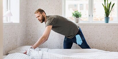 Protect your home from pesky little dust mites with cleaner air tips and tricks. A man making the bed.
