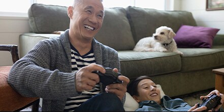 Man playing video games with dog on couch