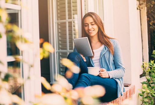 Woman sits outside during spring, reading and enjoying the spring weather.