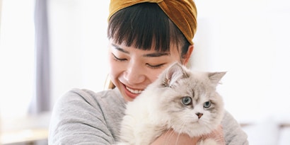 a woman hugging a cat