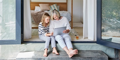 a woman and a child looking at a tablet together