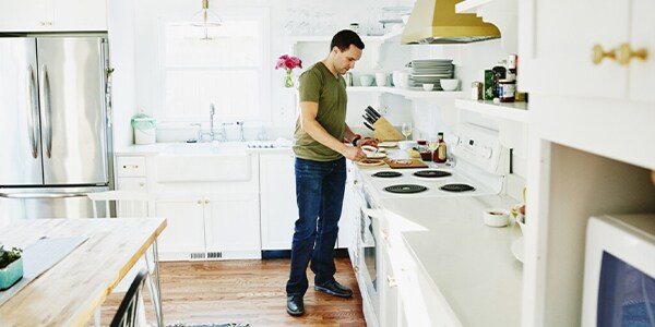 A man preparing a meal in a brightly lit kitchen
